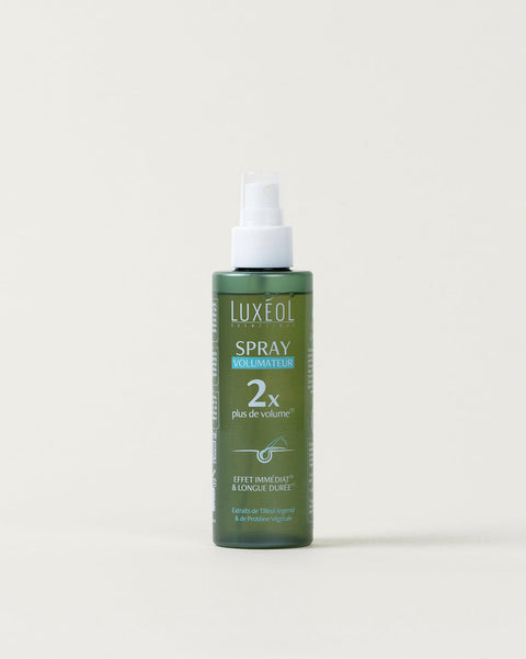 Green spray bottle with white cap on a light beige background