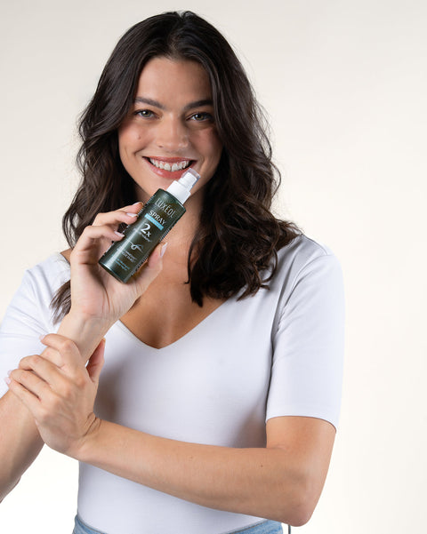 Woman holding a spray bottle with a white background