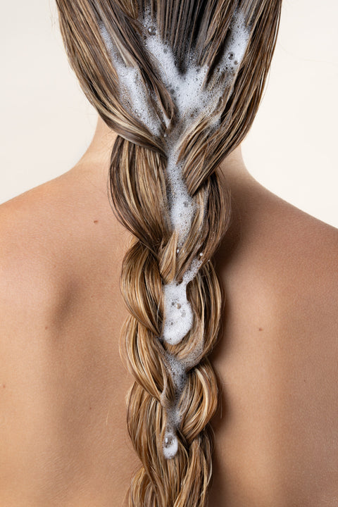 Braided hair with soap suds on a neutral background