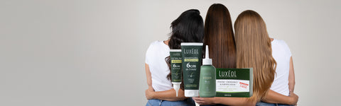 Three women with Luxeol hair care products in front of them on a neutral background